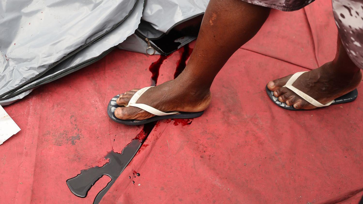 Un hombre camina sobre la sangre de los cuerpos encontrados en el bosque del barrio de Penha, un día después de un operativo policial masivo contra las bandas en las favelas de Río de Janeiro, Brasil.