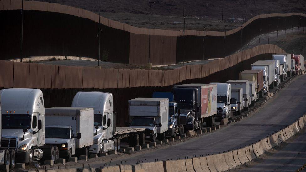 Una hilera de camiones circulan en la frontera entre México y Estados Unidos
