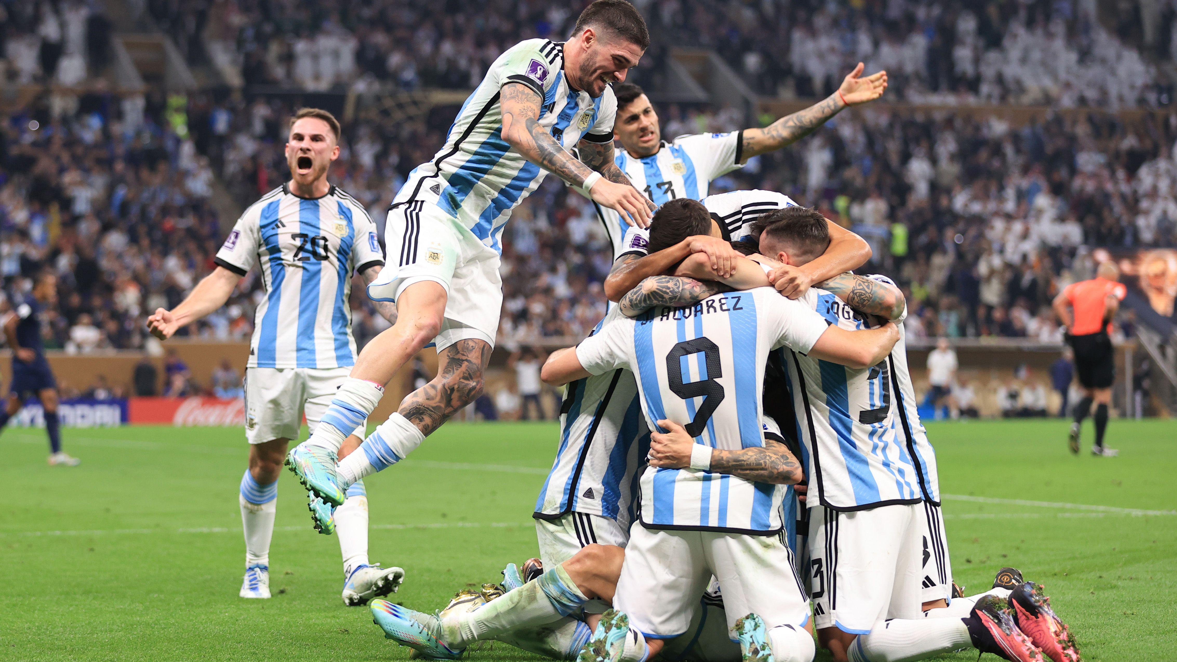 Los jugadores argentinos, vestidos con camisetas a rayas azules y blancas, se arrodillan en el césped y se abrazan para celebrar el segundo gol de su equipo en la final del Mundial 2022 contra Francia.