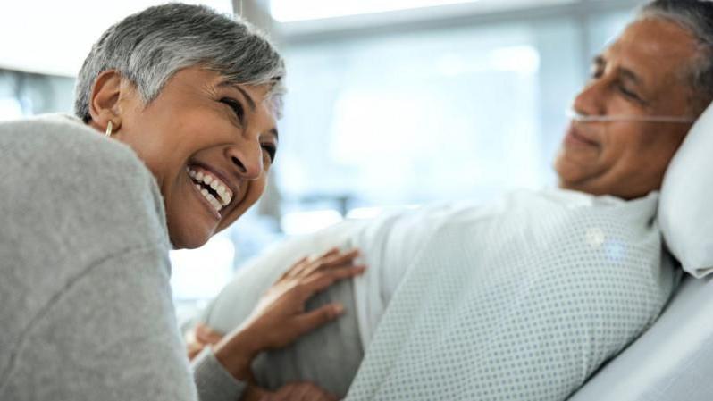 Una mujer atiende a su amigo enfermo en el hospital 