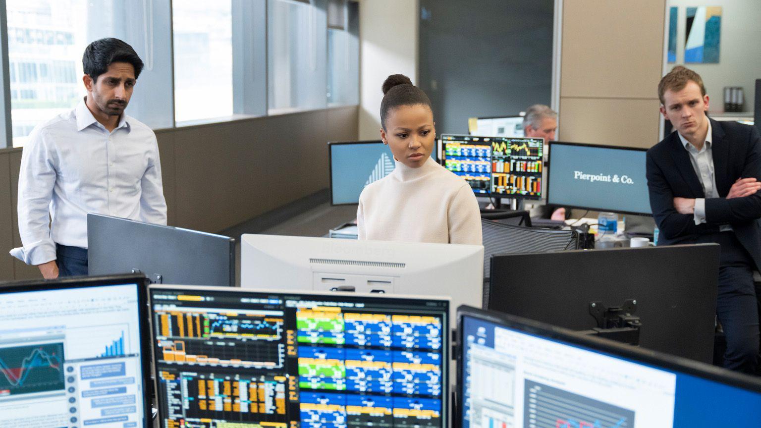 Tr&ecirc;s pessoas de p&eacute; em um escrit&oacute;rio, olhando ao longe