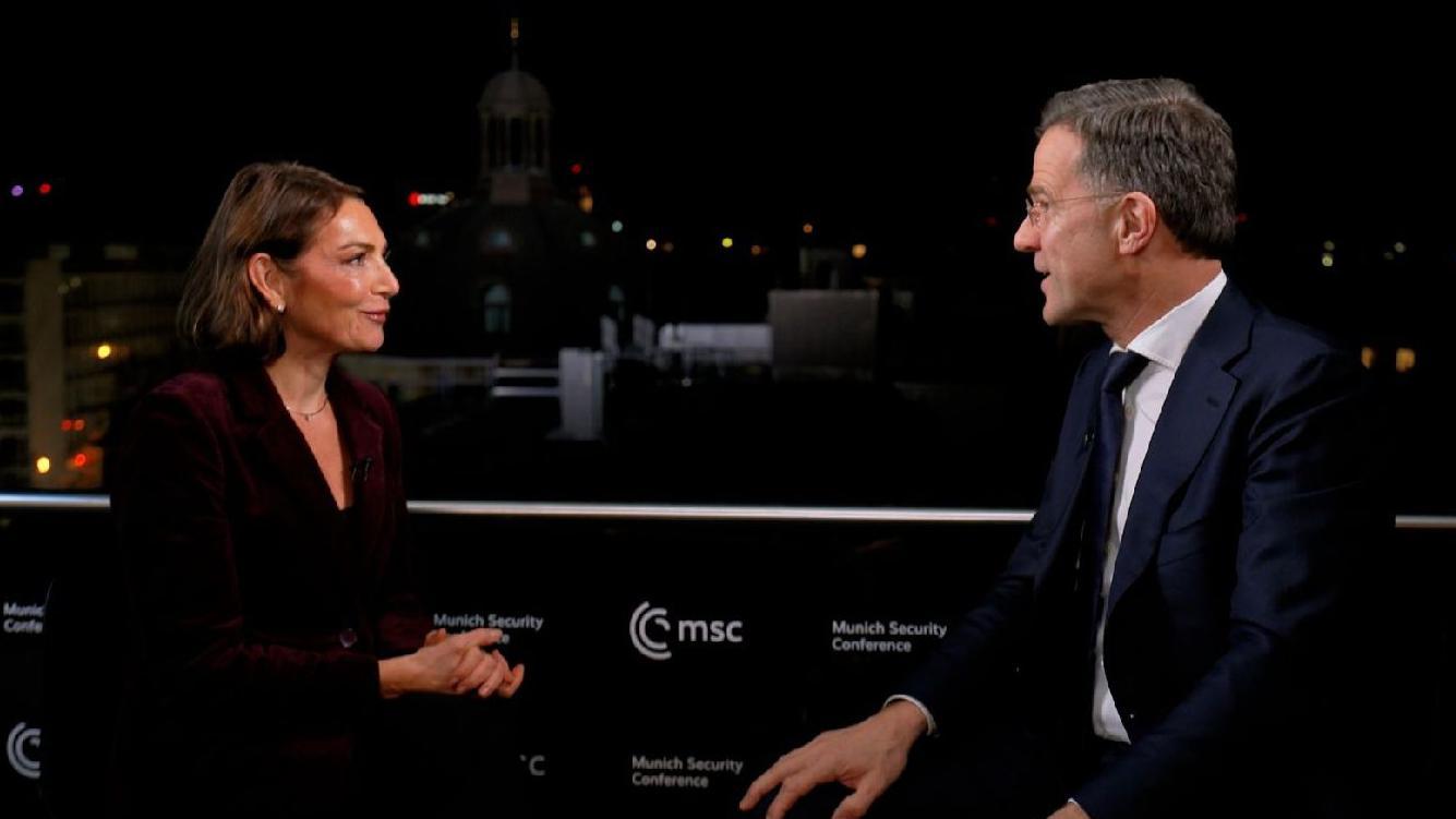 Katya Adler &agrave; esquerda e Mark Rutte &agrave; direita, com um painel da Confer&ecirc;ncia de Seguran&ccedil;a de Munique ao fundo