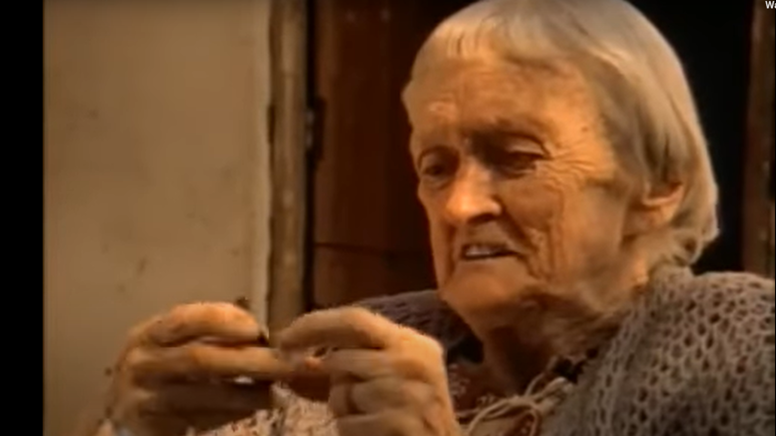 دوروثي إيدي تنظر إلى قلادة صغيرة بين يديها - 1981