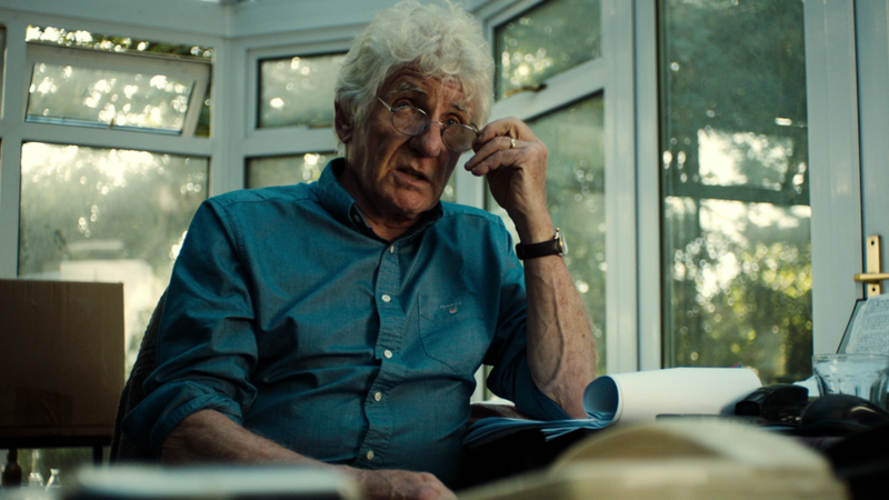 El escritor y periodista Anthony Summers en su escritorio, con camisa azul.