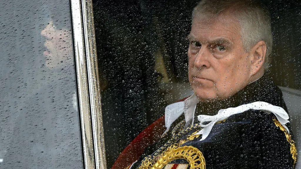 الأمير أندرو مرتدياً لباساً رسمياً ملكياً، شعره أبيض وبشرته بيضاء، ينظر بحدة عبر نافذة يهطل عليها المطر.