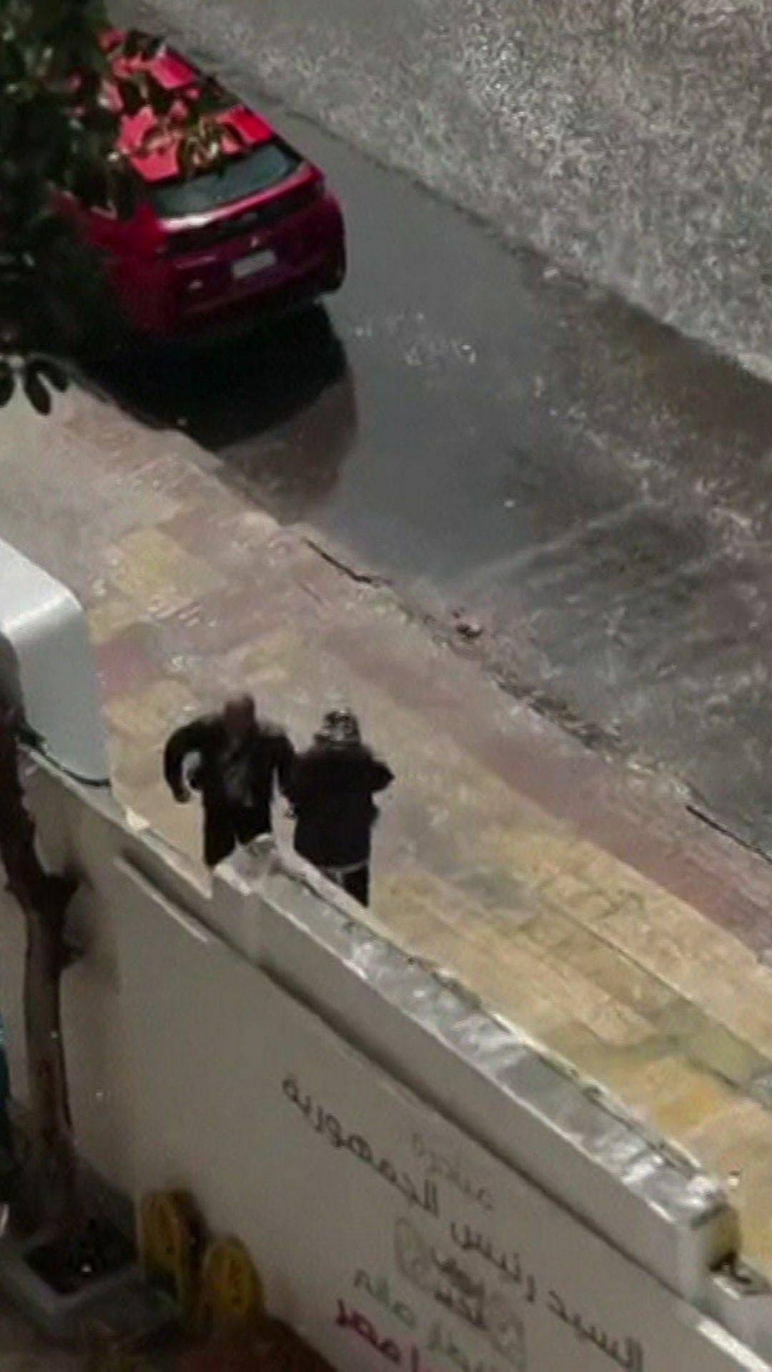 صديقان مصريان يرقصان ببهجة تحت المطر 