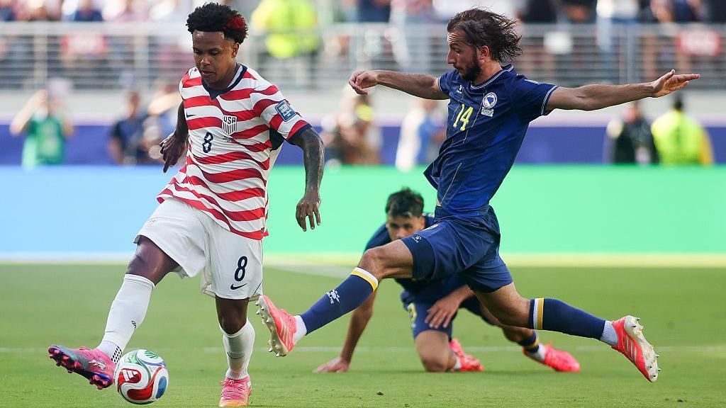 Weston McKennie, de Estados Unidos, disputa un balón con Ivan Sunjic, de Bosnia y Herzegovina y vestido de azul, durante el partido de dieciseisavos.