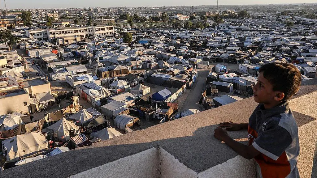 طفل فلسطيني ينظر إلى المخيمات في المواصي