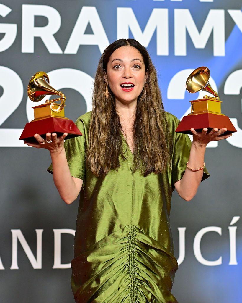 natalia lafourcade sostiene un premio grammy en cada mano