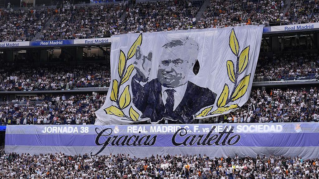 Banner de Carlo Ancelotti em um estádio. 