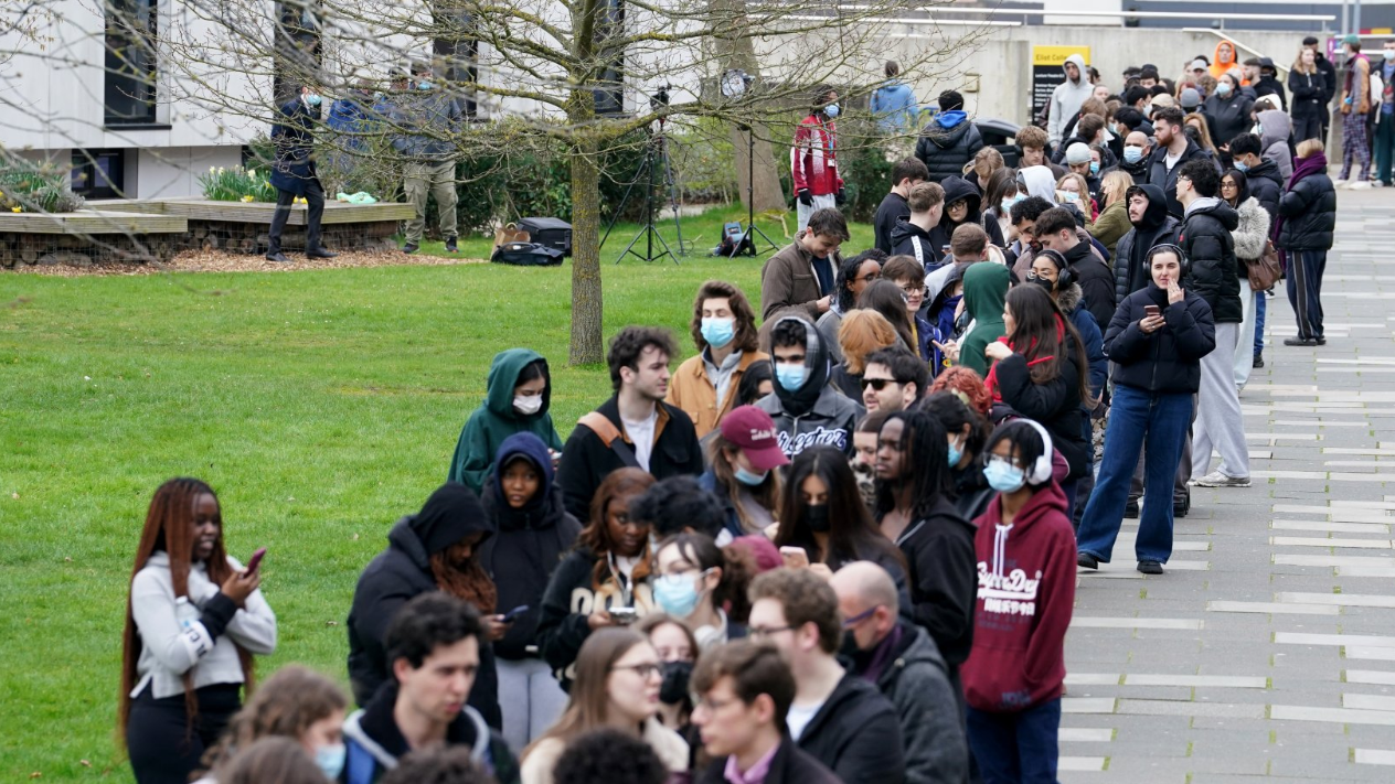 在英國坎特伯雷的肯特大學，學生們在一棟教學大樓外排隊領取抗生素。