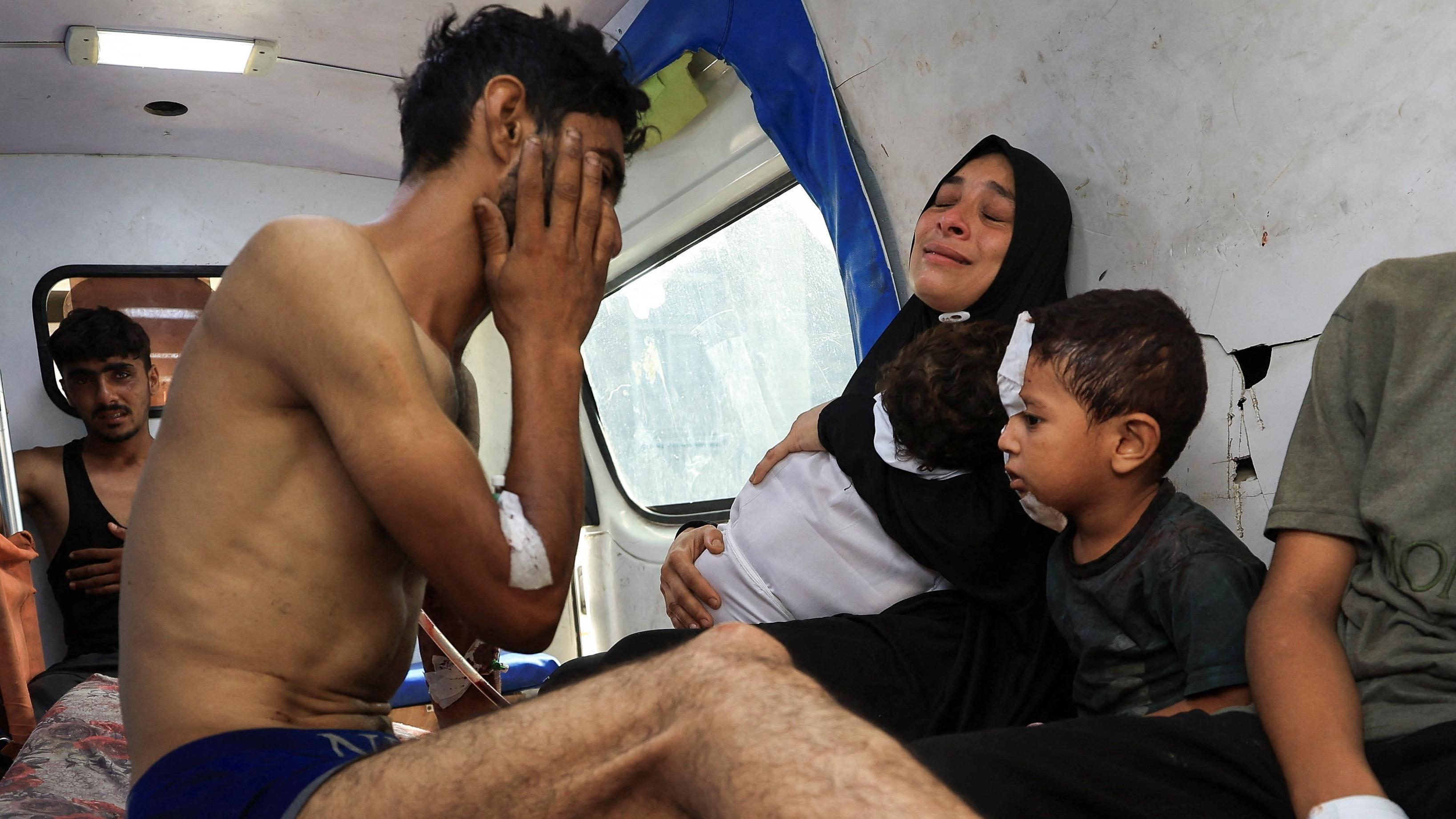 فلسطيني مصاب، يودّع ابنه الذي قُتل في غارة إسرائيلية على خيمة في مدينة غزة.