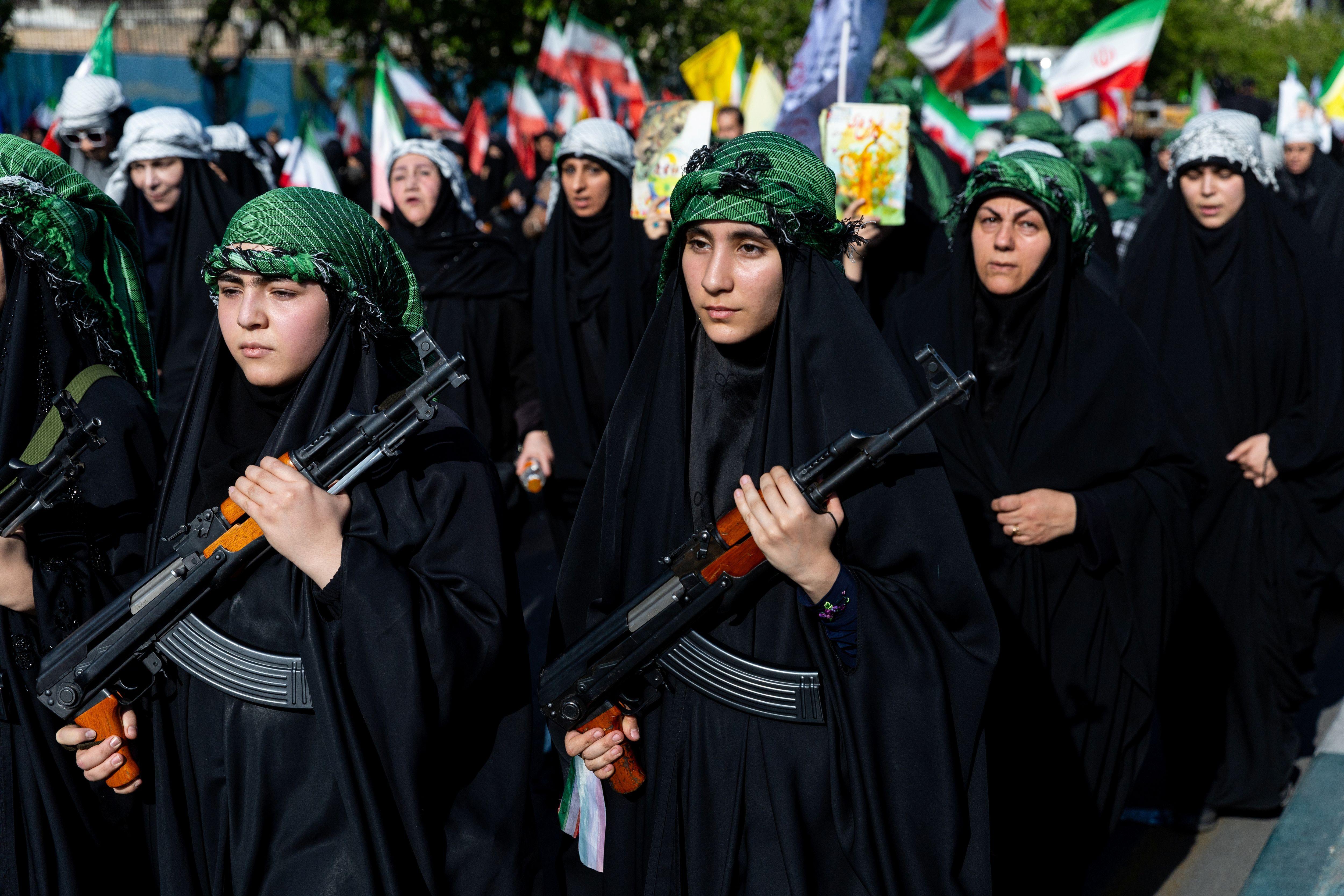 عضوات في قوات الباسيج يحملن أسلحة خلال عرض نسائي مؤيد للحكومة في طهران في أبريل/نيسان 2026.