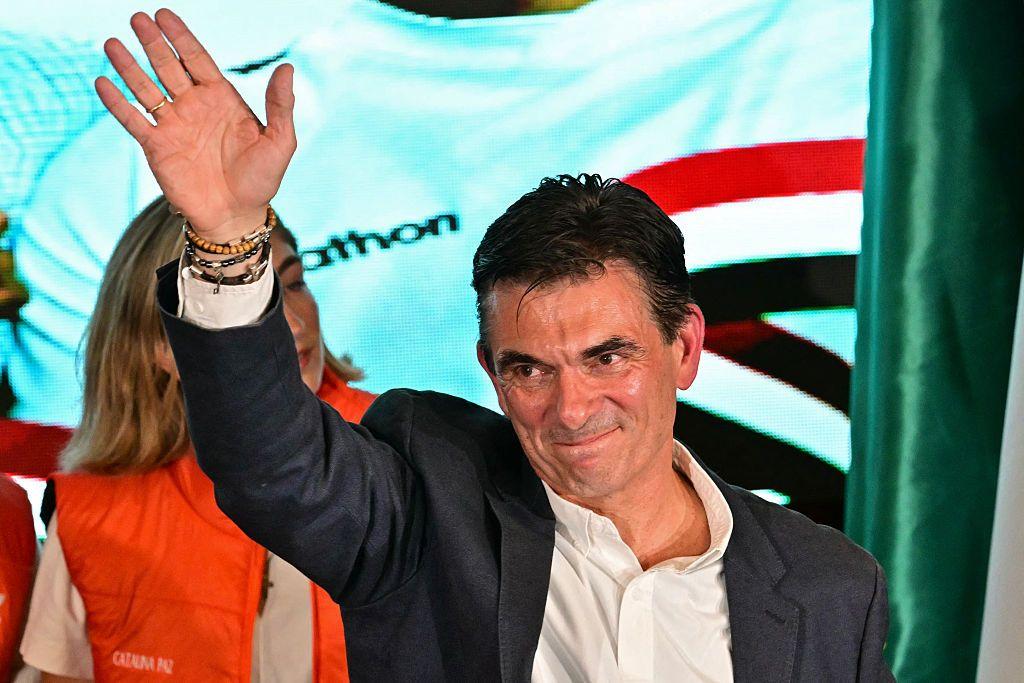 Rodrigo Paz, vestido con chaqueta gris oscura y camisa blanca, levanta el brazo derecho y parece saludar con la mano, mientras al celebrar los resultados de la segunda vuelta de las elecciones presidenciales en La Paz.
