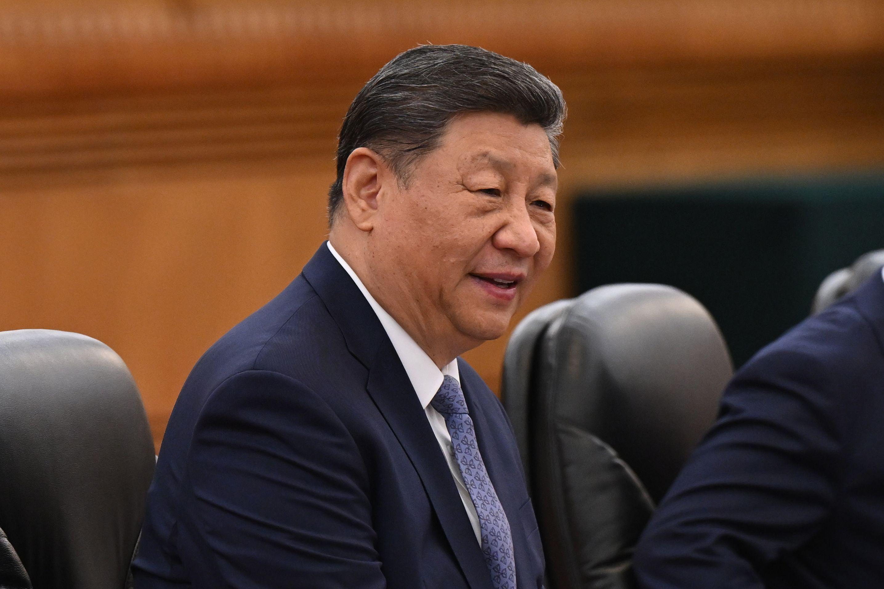 Xi Jinping de terno e gravata sorrindo