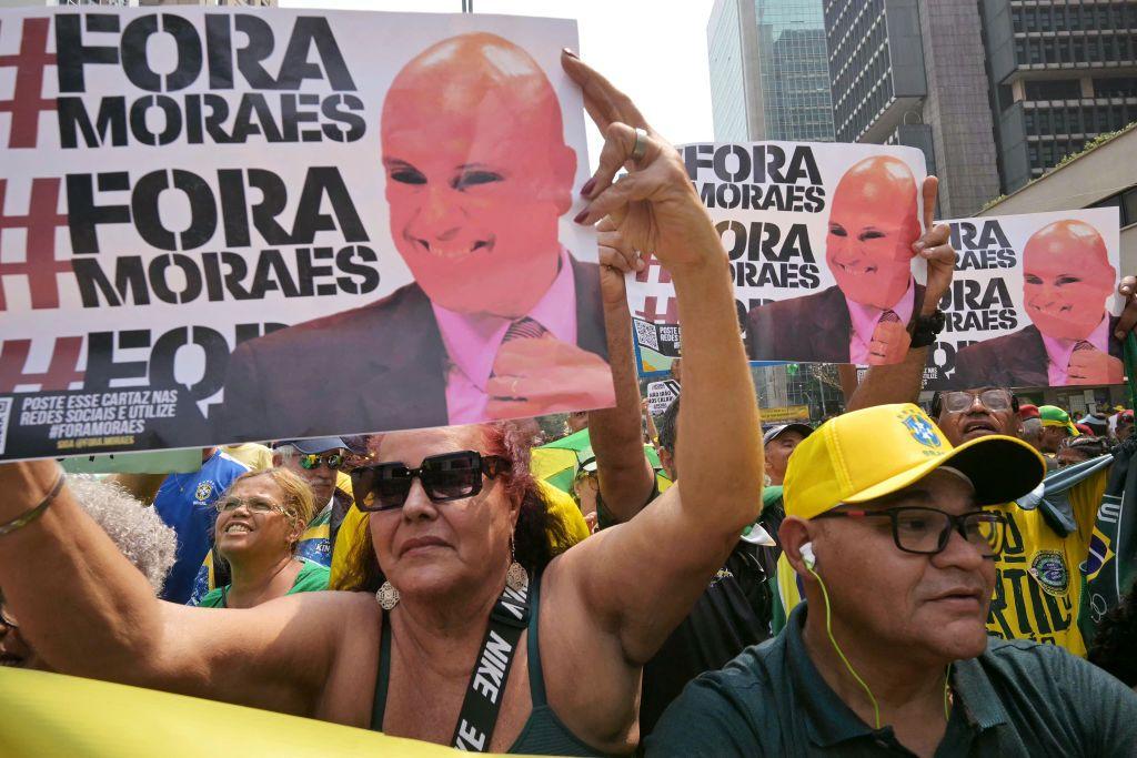 Seguidores de Bolsonaro con carteles que leen "Fuera Moraes", con la imagen del juez Alexandre de Moraes.