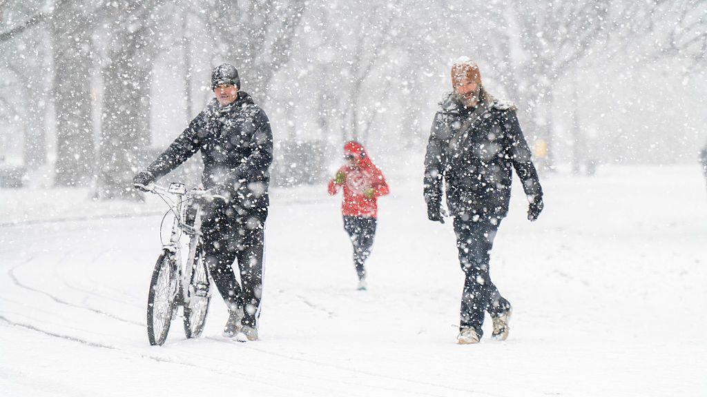 Tres personas caminan en la nieve en Nueva York