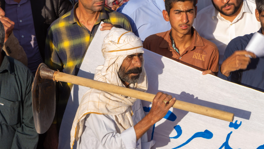 رجل يرتدي لباساً تقليديا محليا يحمل على كتفه فأساً في مظاهرة احتجاجية ضد سياسات الحكومة