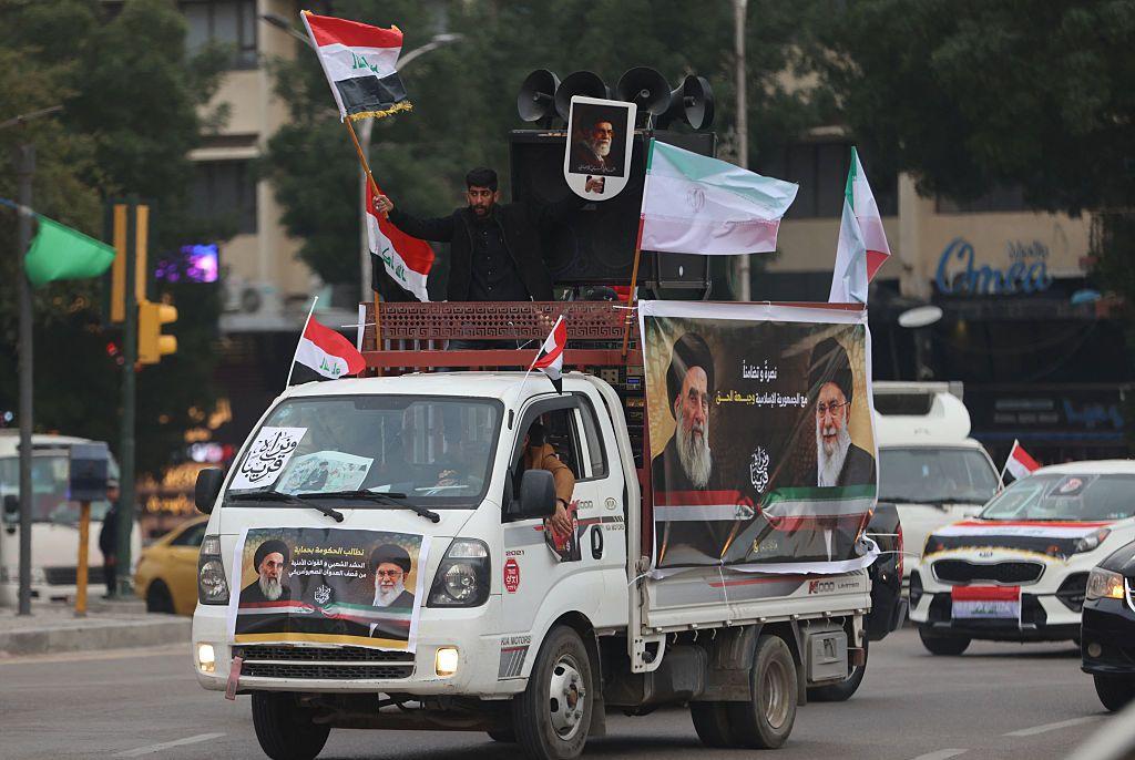 صورة تظهر رجل عراقي يلوح بعلم بلاده خلال تجمع مؤيد لإيران في ساحة التحرير ببغداد، 2 أبريل/ نيسان 2026. 