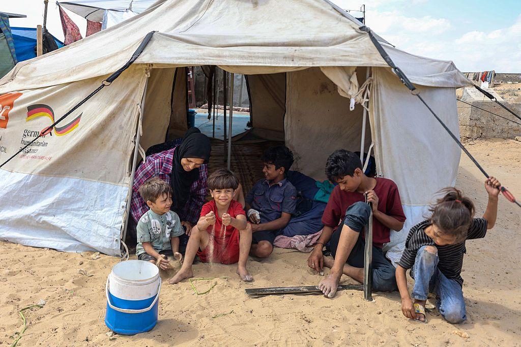 رندة مصلح، 44 عاماً، تجلس مع أطفالها في خيمة نُصبت في مخيم مؤقت وسط مقبرة في خان يونس جنوب قطاع غزة، في 25 سبتمبر/أيلول 2025، في خضم الصراع الدائر بين إسرائيل وحركة حماس الفلسطينية المسلحة