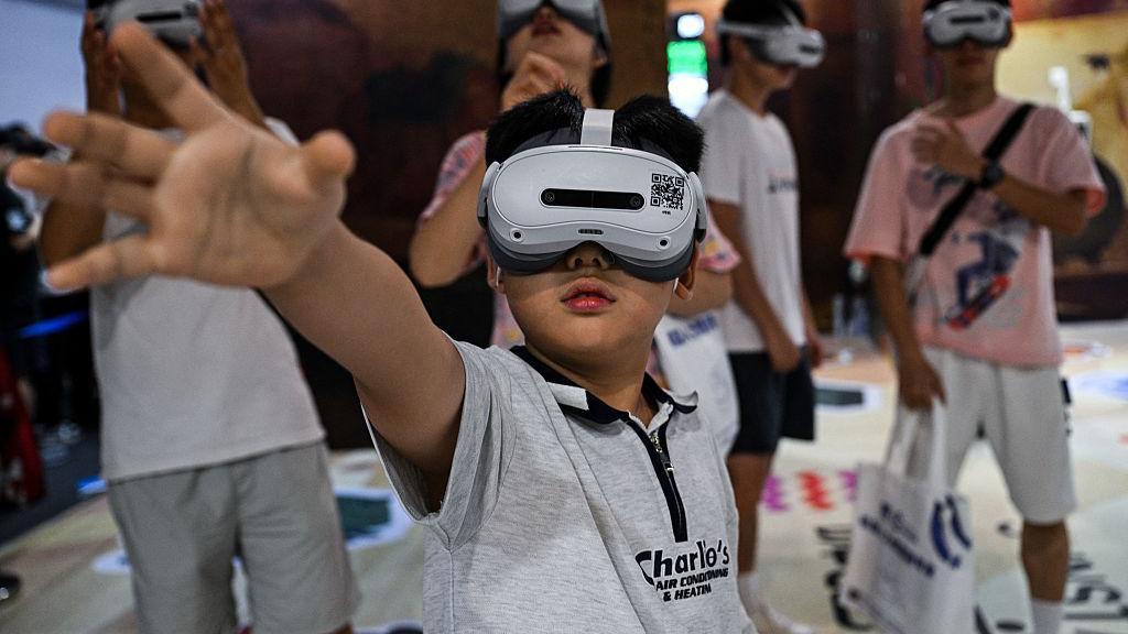 Un niño con gafas de realidad aumentada extiende su brazo derecho