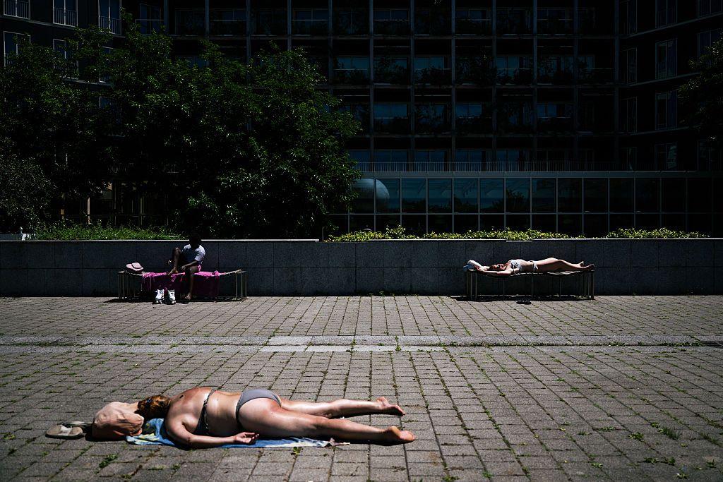 Gente tomando sol en el parque público André-Citroën en París el 29 de junio de 2025 mientras una ola de calor azota Europa.