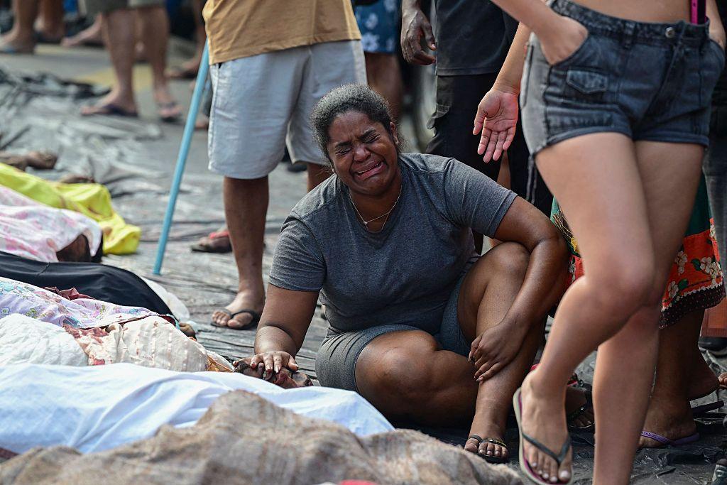 Mulher chora ao lado de corpo no Rio de Janeiro
