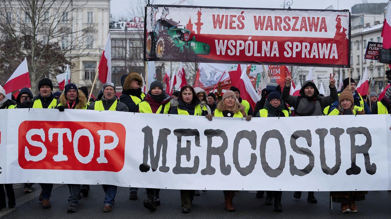 Fazendeiros poloneses seguram uma faixa em protesto contra o acordo comercial Mercosul no centro de Varsóvia, Polônia, em 9 de janeiro de 2026.