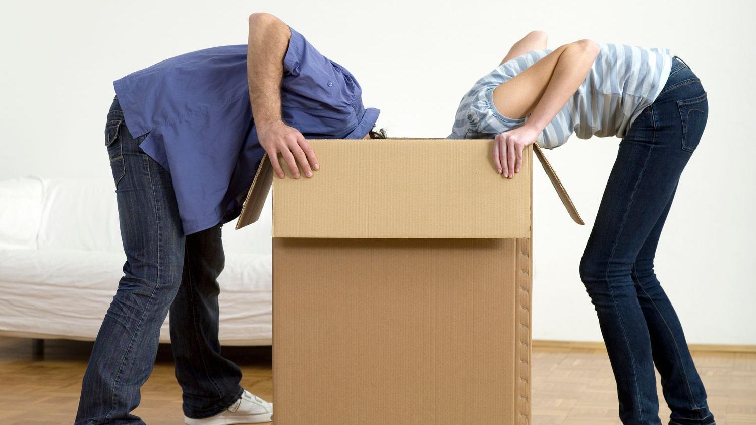 Hombre y mujer buscan algo en una caja. 