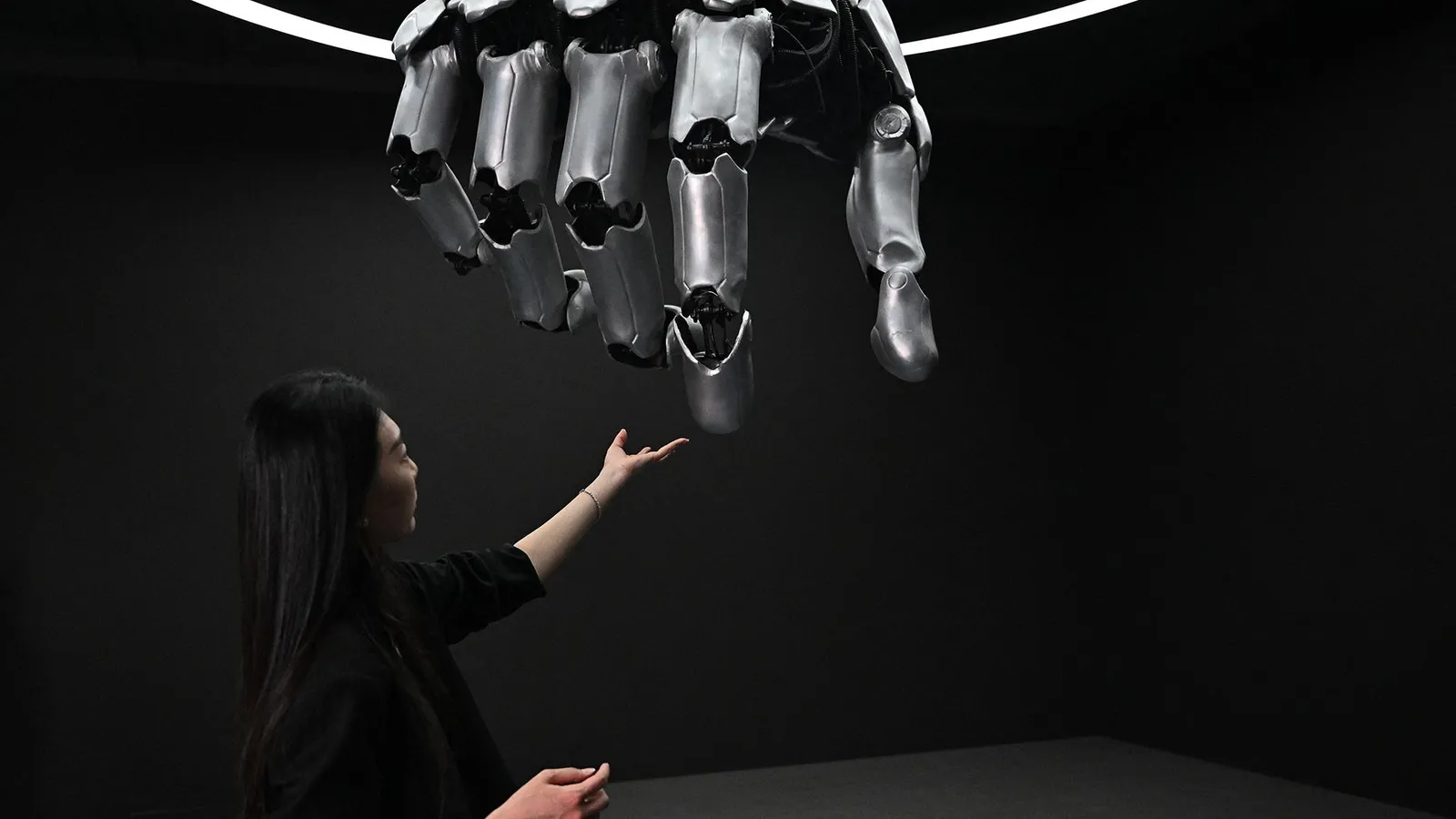 فتاة تلمس يدا آلية ضخمة