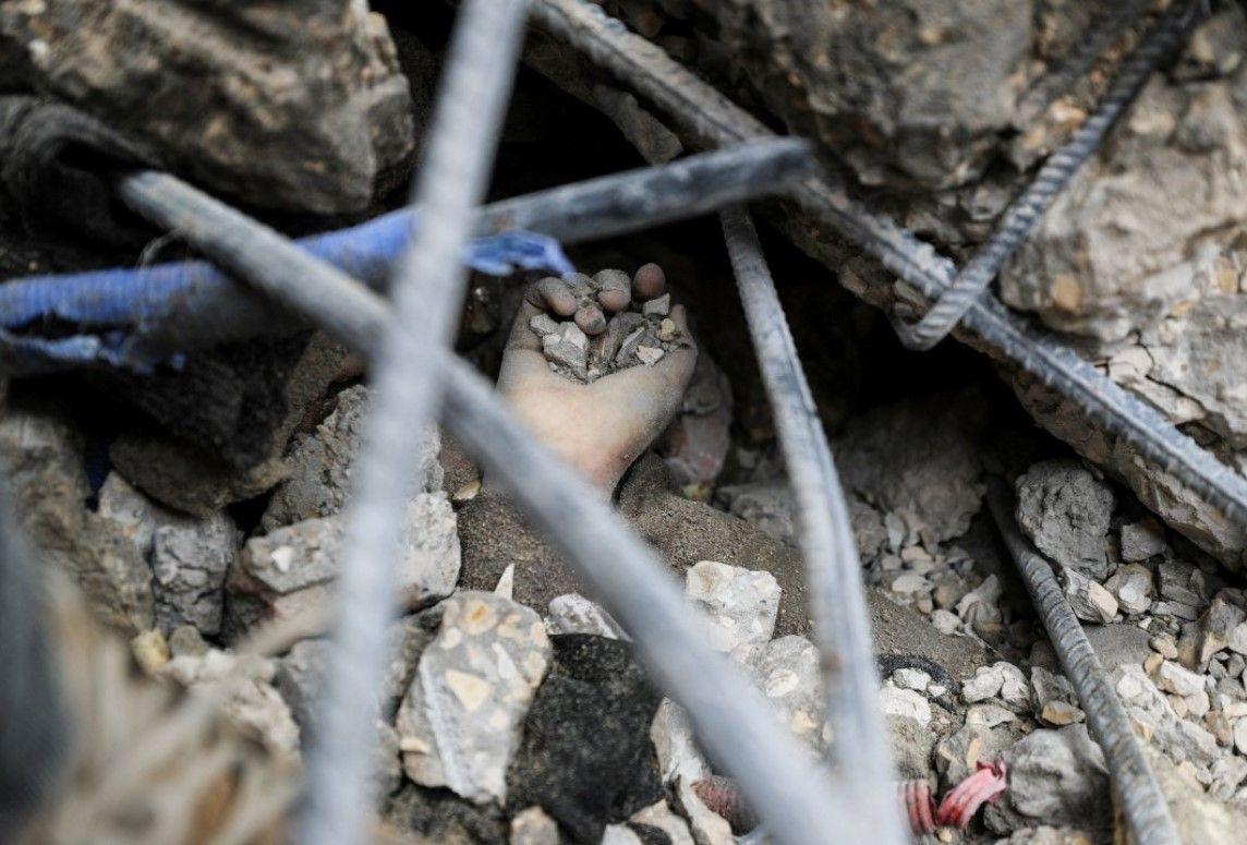 تظهر يد فلسطيني ميت تحت الأنقاض، في موقع غارة إسرائيلية على منزل، في جباليا شمال قطاع غزة، 13 أبريل/نيسان 2025.
