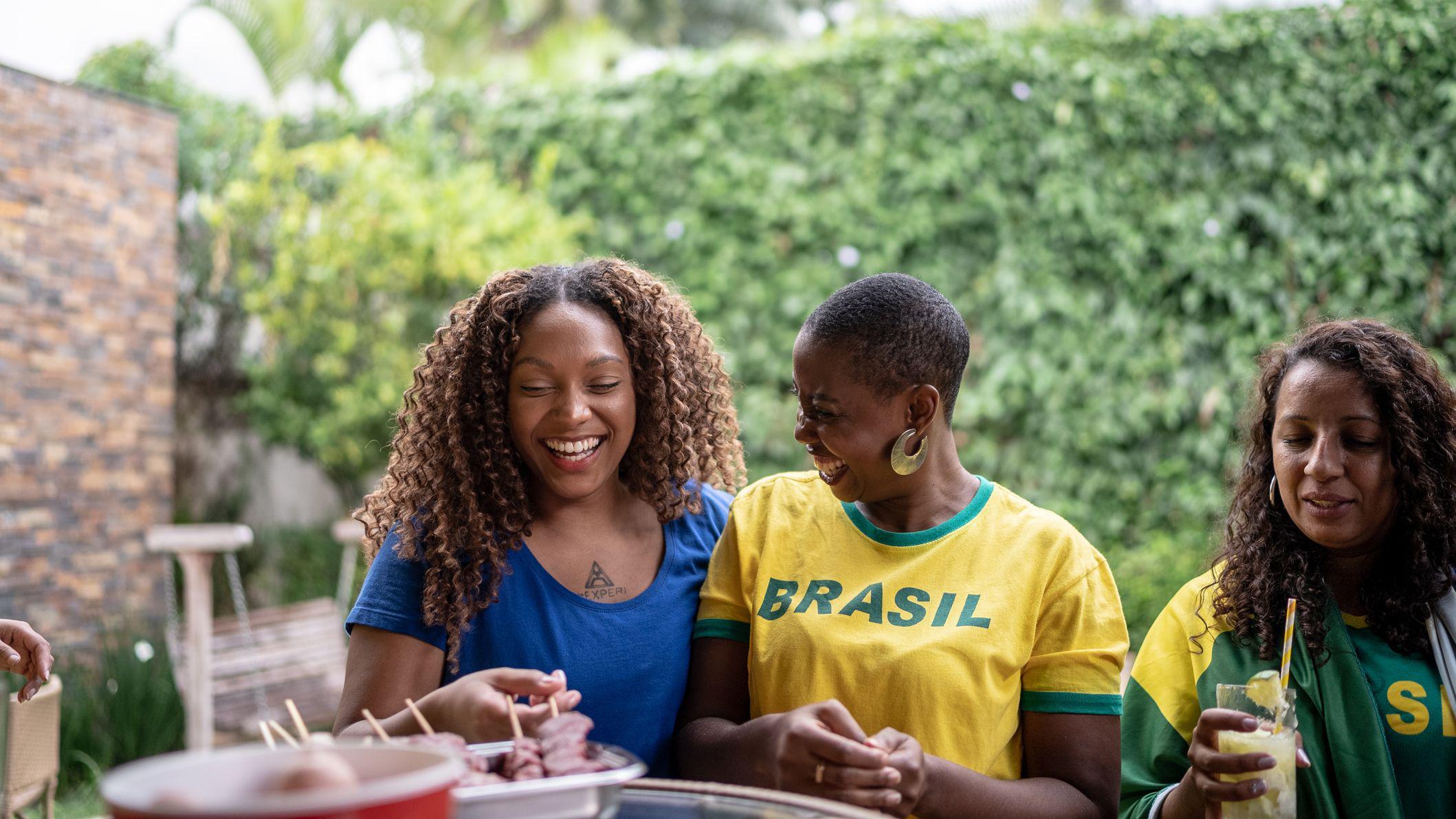 Três mulheres comendo churrasco