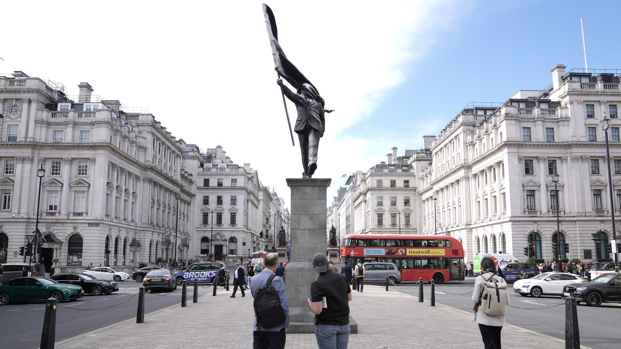 Ljudi posmatraju statuu, benksi, benksijeva statua u londonu