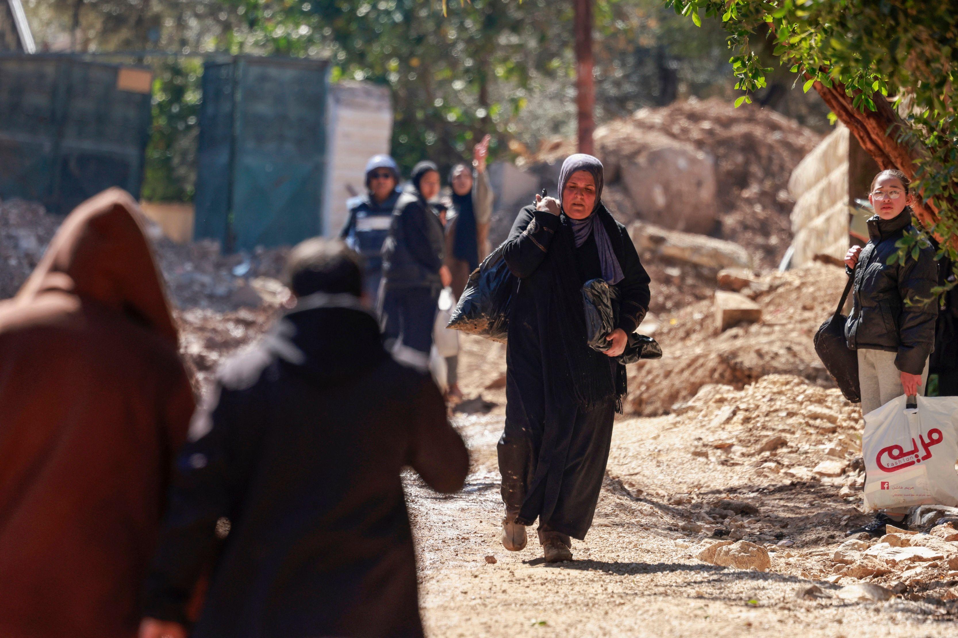 نازحون فلسطينيون يحملون متعلقاتهم خلال هجوم شنه الجيش الإسرائيلي على مخيم جنين للاجئين في الضفة الغربية المحتلة، في 25 فبراير/شباط 2025