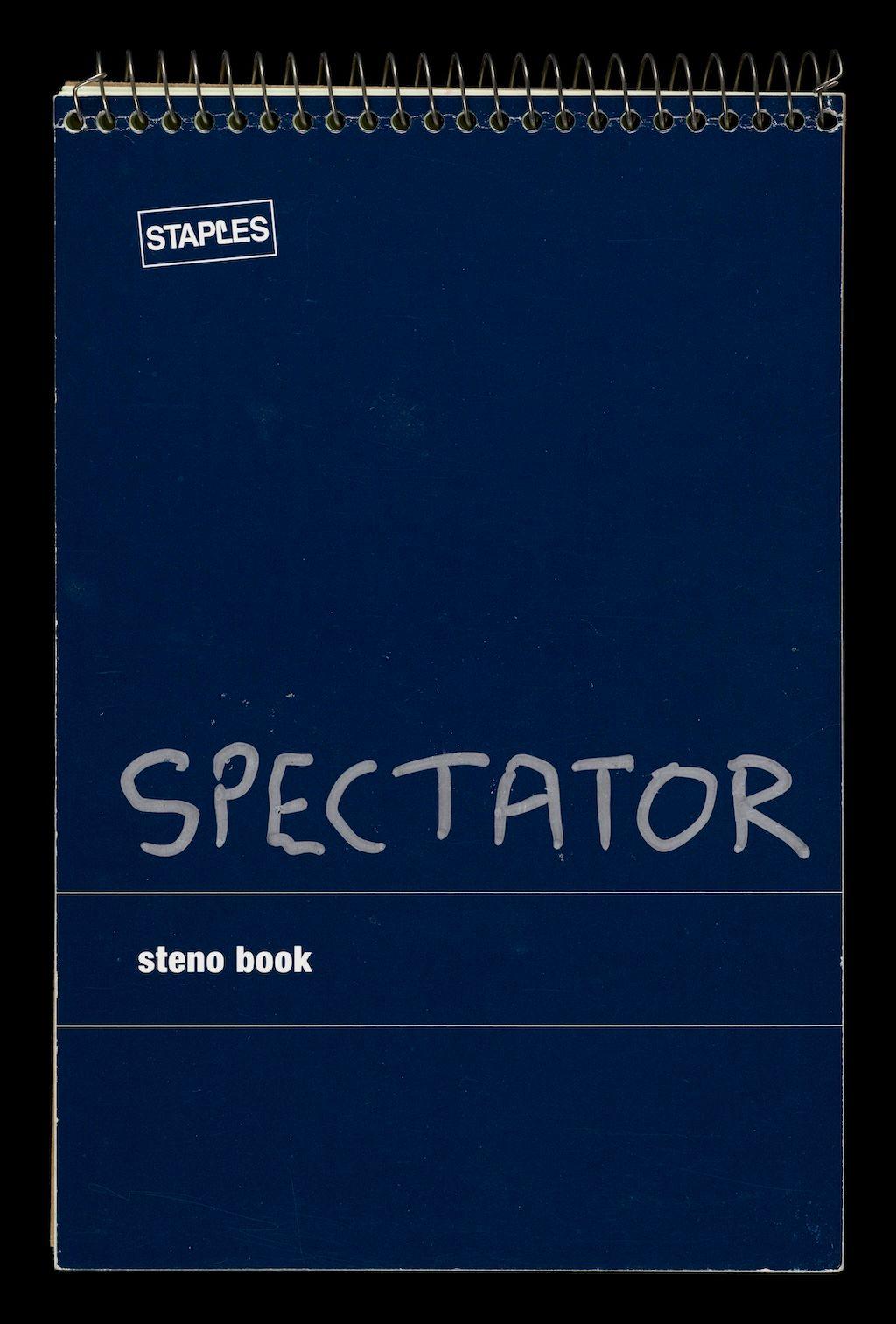 Un cuaderno de espiral azul, con la palabra Spectator escrita en el frente con bolígrafo plateado.