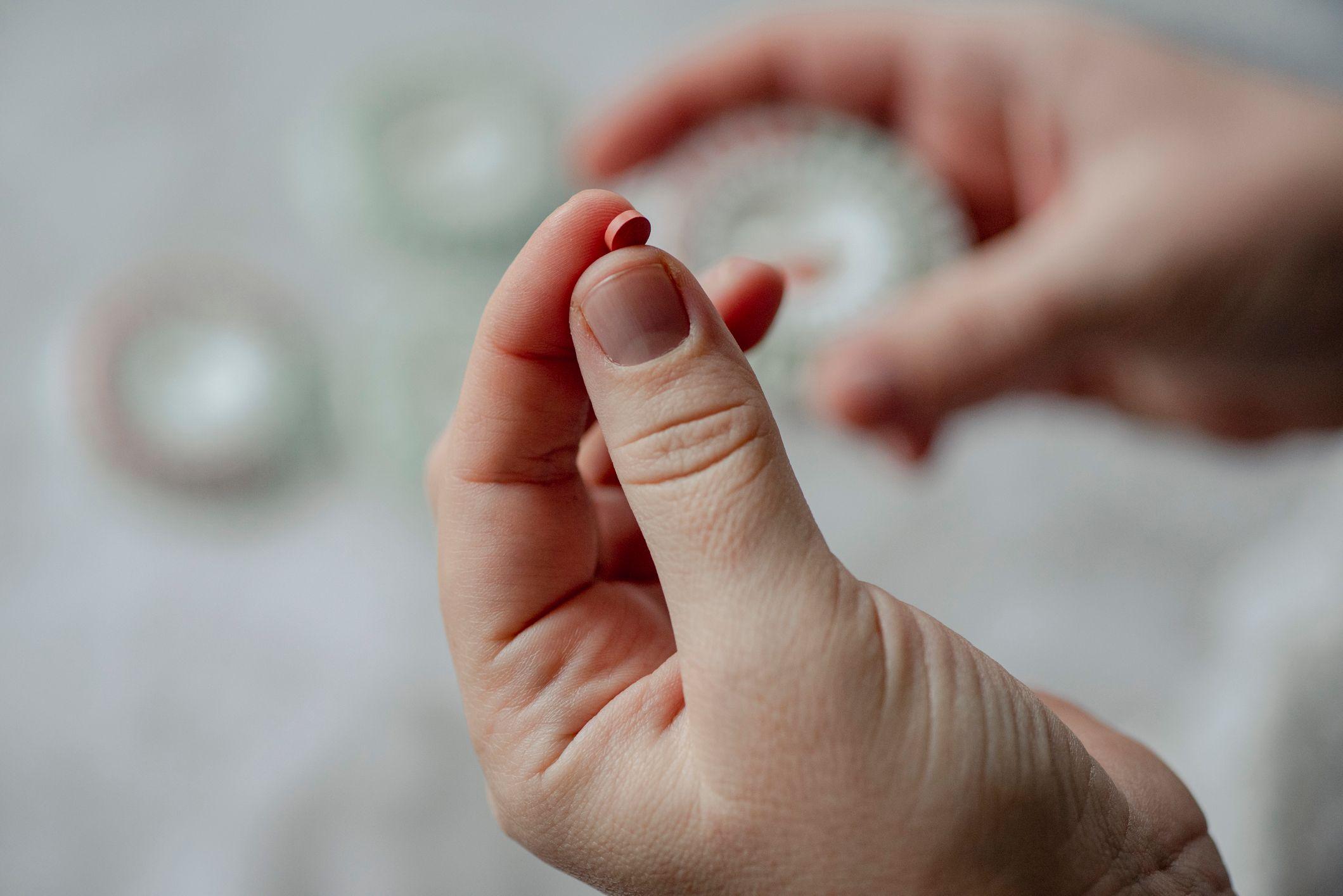 يد تمسك بحبة دواء