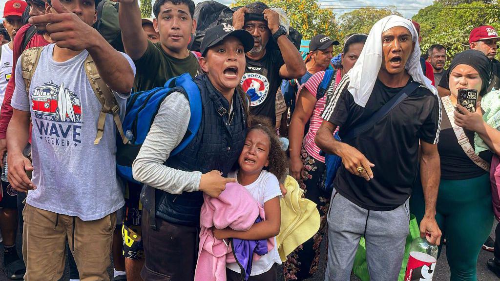 Migrantes hablan con miembros del Servicio Nacional de Fronteras de Panamá mientras intentan cruzar la frontera entre Panamá y Costa Rica.