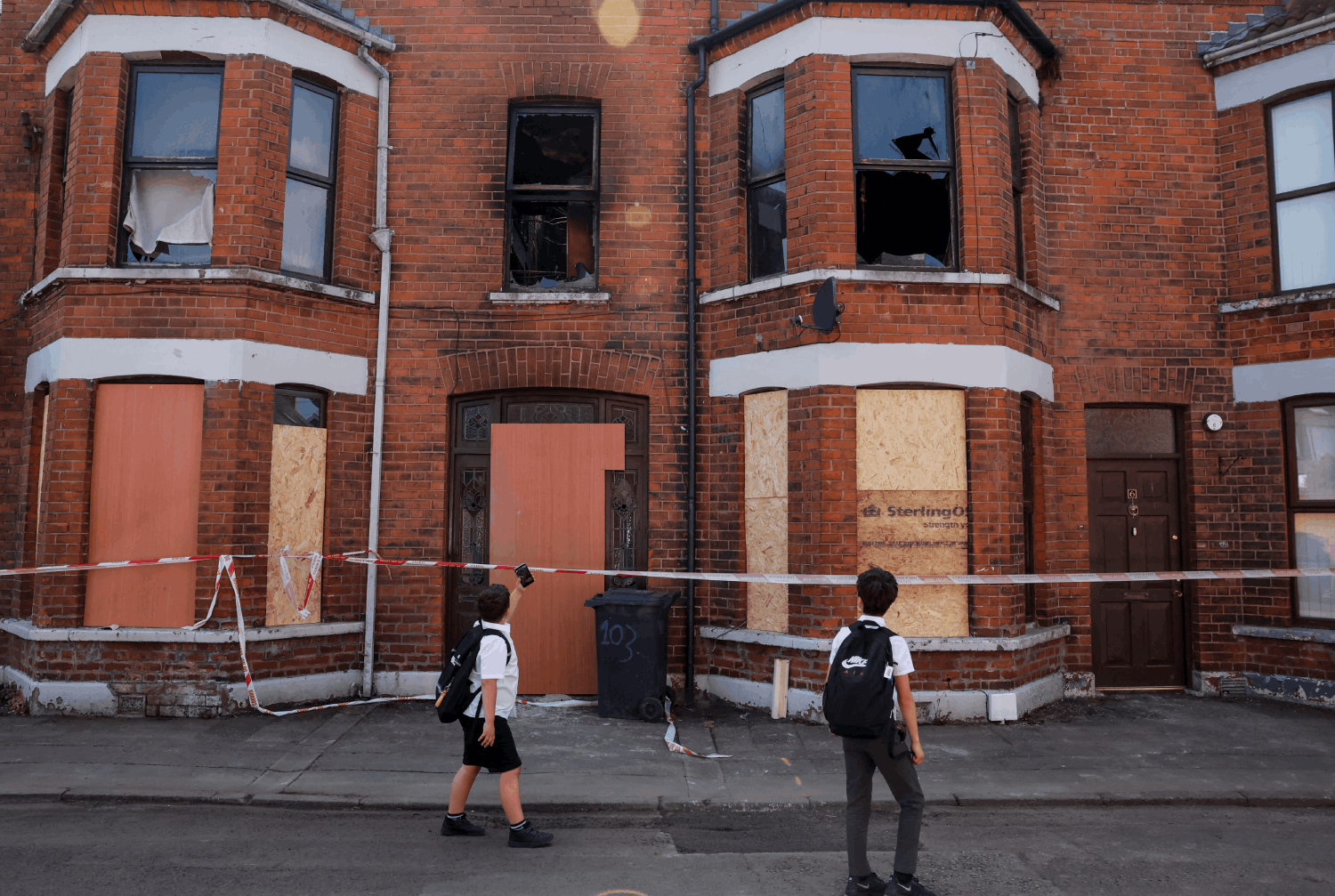 Unos niños frente a una casa atacada en Ballymena.