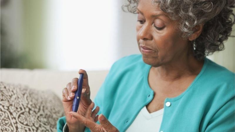 Mulher usa agulha no dedo para medir glicose 