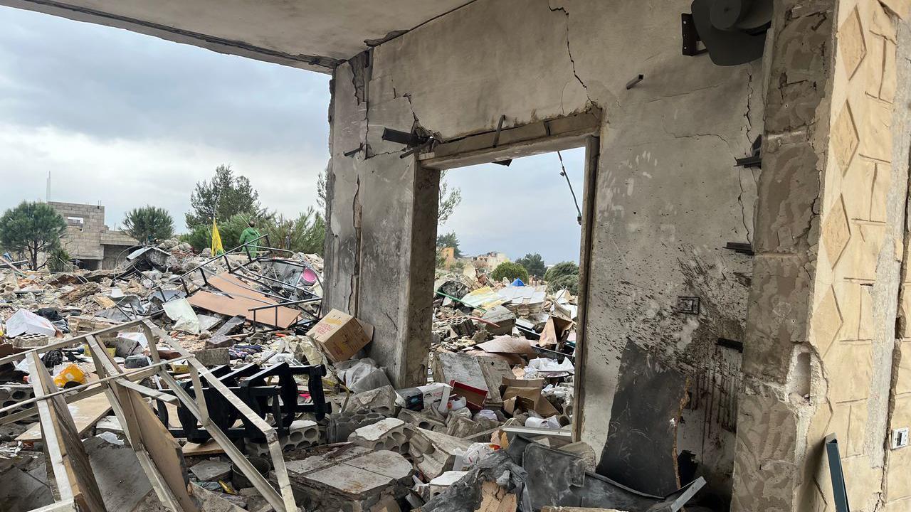 أنقاض المنزل بجوار جدار متبقٍ به مدخل