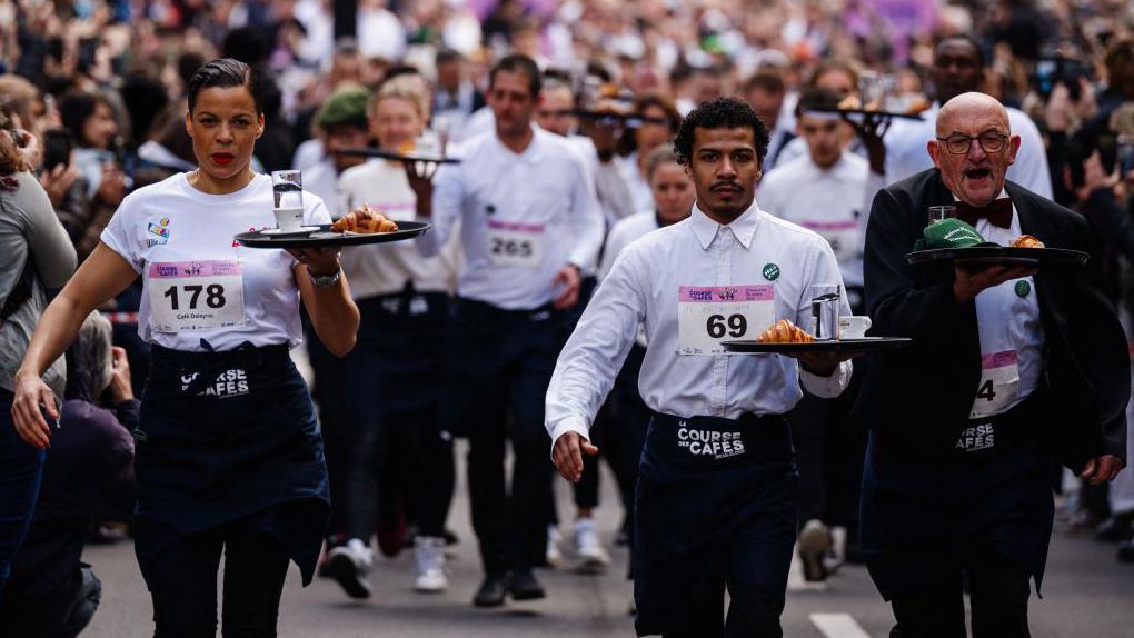 تقليد سنوي لسباق بين عمال وعاملات المقاهي الباريسية، ندل ونادلات باللباس التقليدي للمقهى الفرنسي وصينية مع فنجان قهوة وقطعة كرواسان