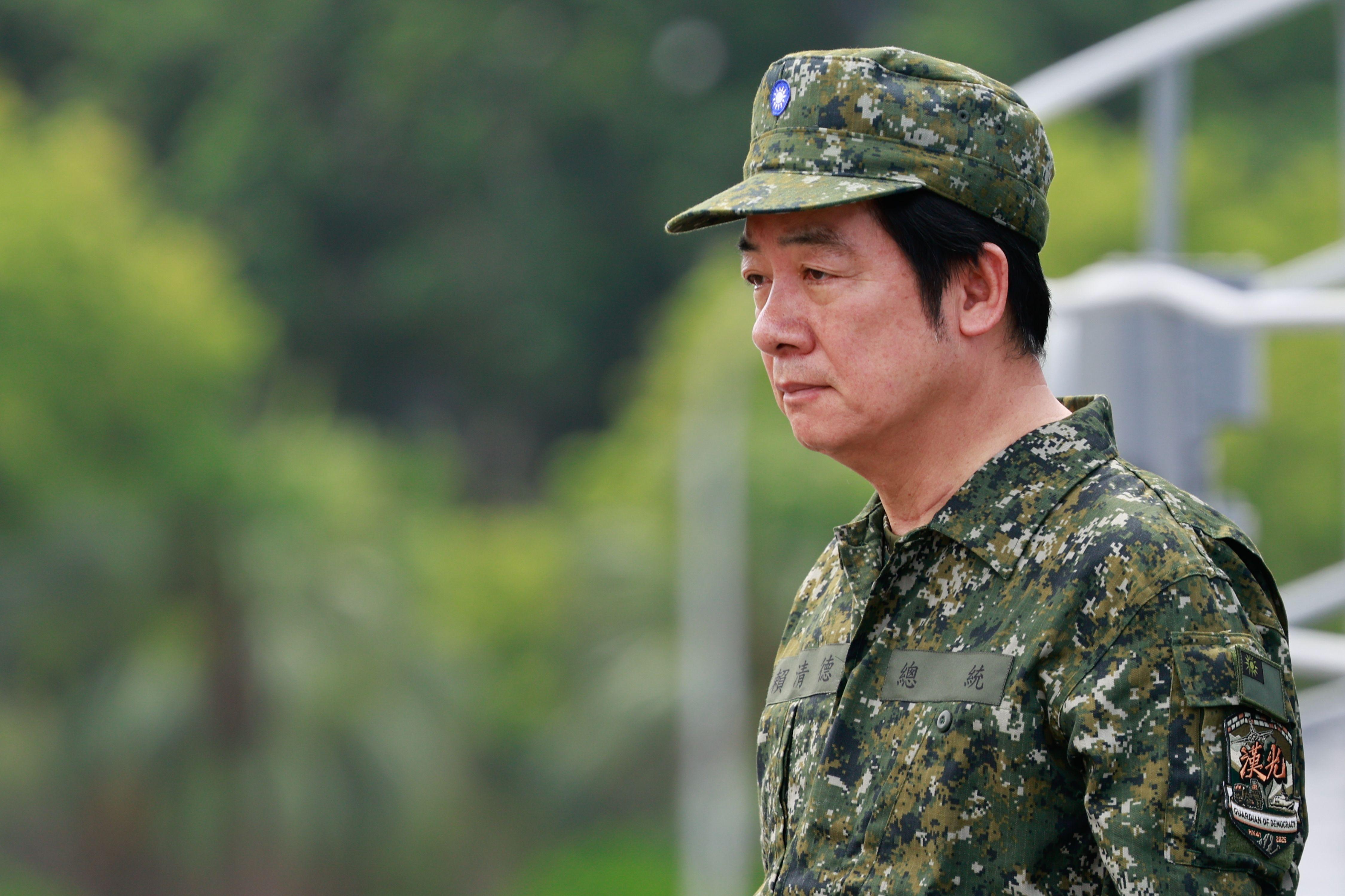 William Lai usando uma roupa verde camuflada e um boné