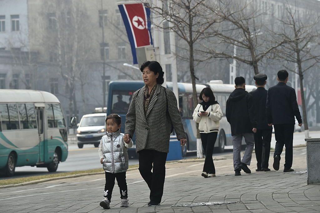Personas y vehículos transitan por una calle de Pyongyang. 