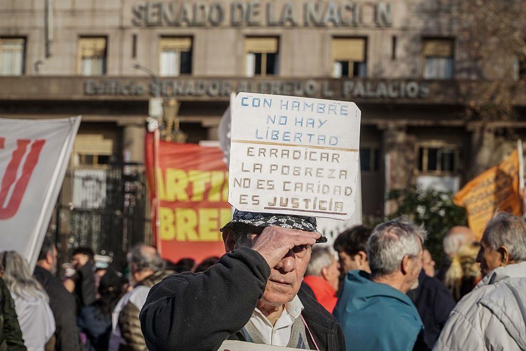 Un hombre sostiene un cartel contra el hambre y la pobreza durante la Marcha de los Jubilados frente al Congreso Nacional en Buenos Aires, Argentina, el 30 de julio.