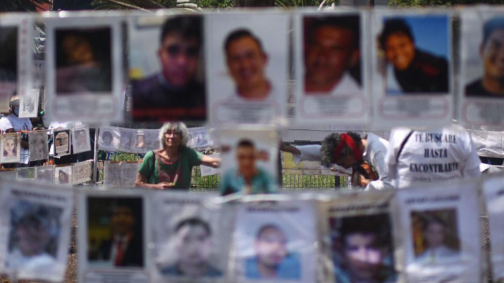 Familiares de desaparecidos, ao lado de suas fotos no México