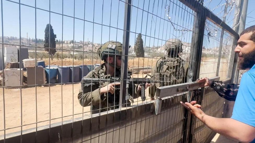 Soldados israelíes amenazan con armas a un palestino 