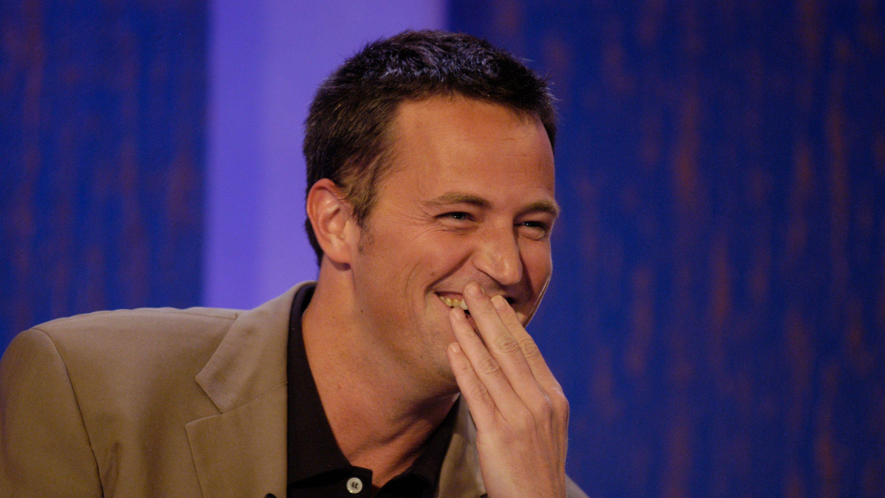 metju peri prekriva lice rukom dok se smeje u televizijskoj emisiji