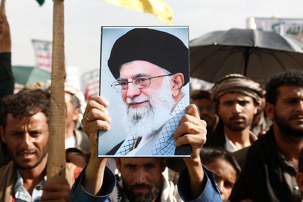 Manifestantes en Irán sostienen una foto de Alí Jamenei.