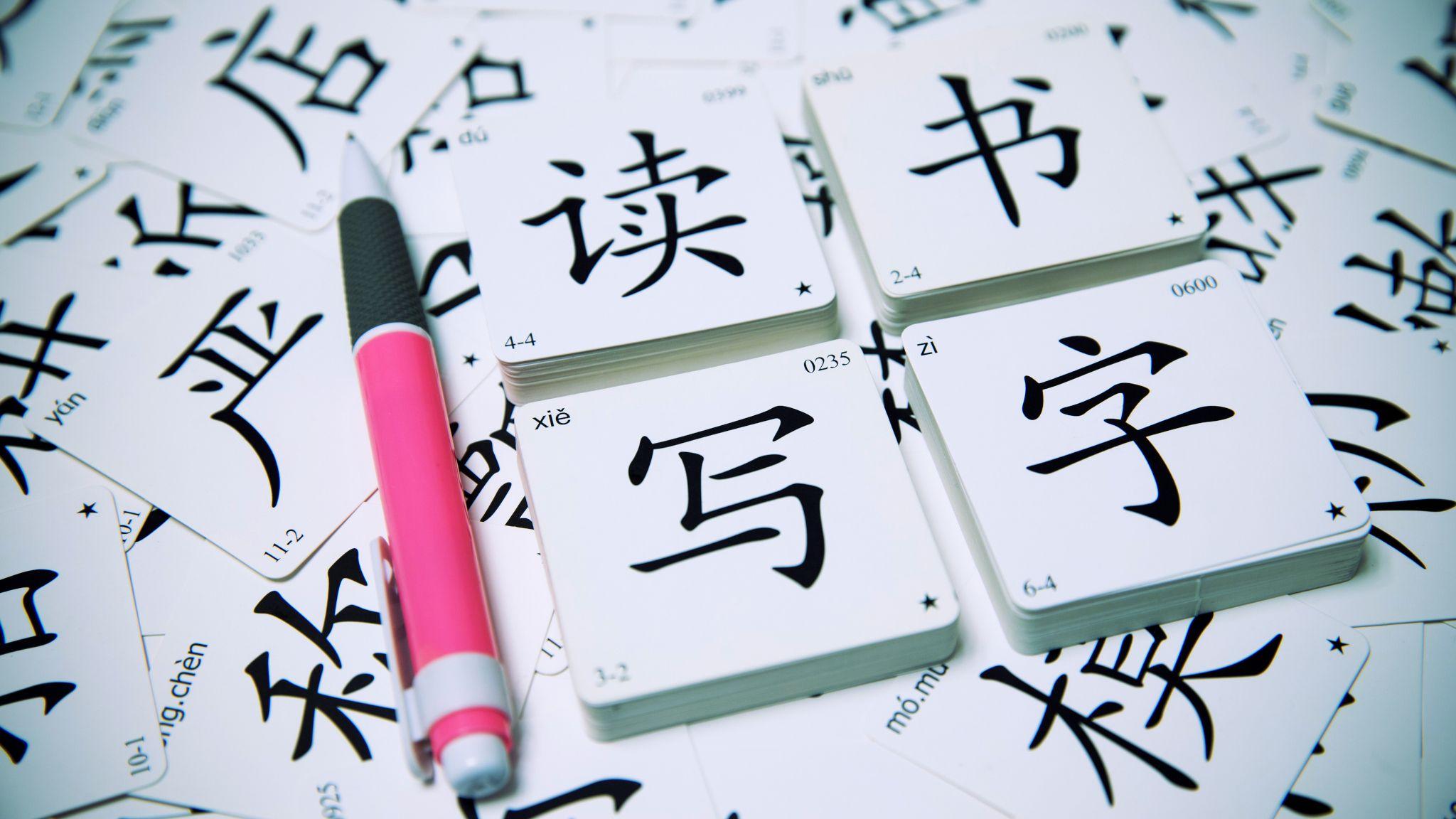 設計圖片：簡體中文學習字卡「讀書寫字」，旁邊放有一支原子筆