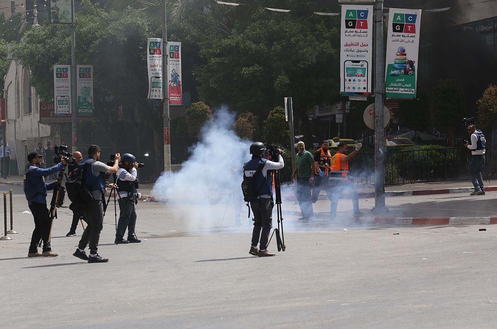 صحفيون يقفون في الشارع خلال اشتباك بين القوات الإسرائيلية وفلسطينيين، بعد مداهمة في نابلس، بالضفة الغربية، في ٢٧ مايو/أيار ٢٠٢٥.
